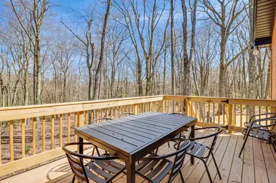 a wooden deck with a wooden table and chairs at Walk to Water Park Split-Rock Resort Home with Deck in Lake Harmony