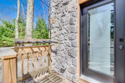 a front door of a home with a stone wall at Walk to Water Park Split-Rock Resort Home with Deck in Lake Harmony