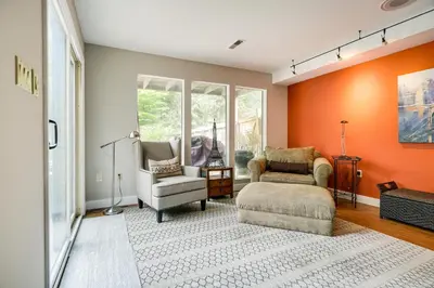 a living room with two chairs and an orange wall at 3 Mi to Downtown Inviting Lancaster Home! in Lancaster