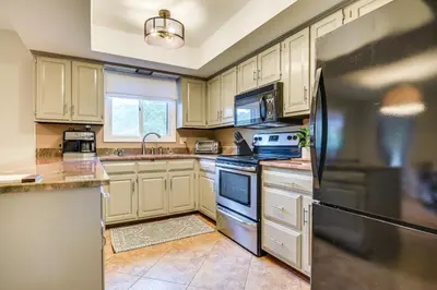 a kitchen with white cabinets and a black refrigerator at 3 Mi to Downtown Inviting Lancaster Home! in Lancaster