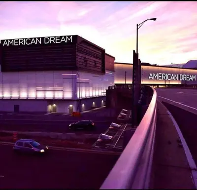 a parking lot with cars parked in front of a building at RentalsOP NJ01 Full house minutes from NYC, near to metlife, American Dream in Hackensack
