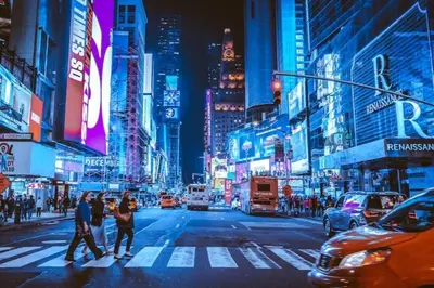 a group of people crossing a busy city street at night at RentalsOP NJ01 Full house minutes from NYC, near to metlife, American Dream in Hackensack
