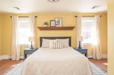 a bedroom with a bed with two night stands and two windows at Dutch Country Acres in New Providence
