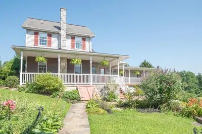 an old house with a porch and flowers at Dutch Country Acres in New Providence