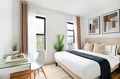 a bedroom with a bed and a desk with a glass table at 444-3F Newly renovated 1BR in Hell's Kitchen in New York