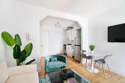 a living room with a blue chair and a table at 444-3F Newly renovated 1BR in Hell's Kitchen in New York