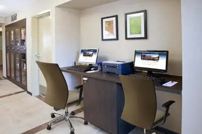 an office with two computers on a desk with chairs at Candlewood Suites Sayre by IHG in Sayre