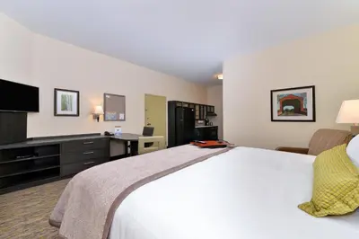 a hotel room with a large bed and a television at Candlewood Suites Sayre by IHG in Sayre