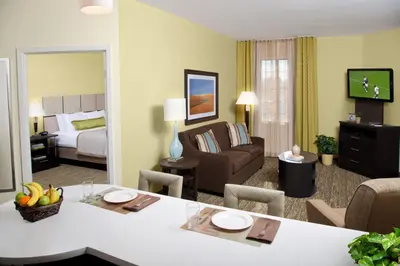 a hotel room with a living room with a bedroom at Candlewood Suites Sayre by IHG in Sayre