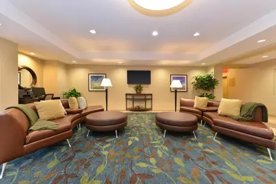 a hotel lobby with couches and a flat screen tv at Candlewood Suites Sayre by IHG in Sayre