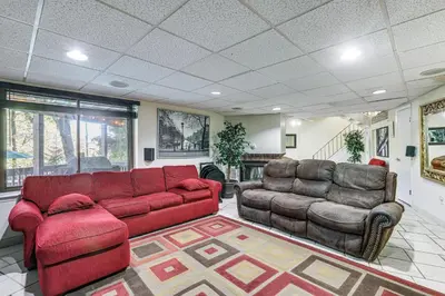 a living room with a red couch and two chairs at Spacious King of Prussia Home with 2 Game Rooms in King of Prussia