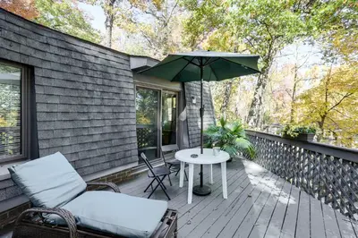 a patio with a table and chairs and an umbrella at Spacious King of Prussia Home with 2 Game Rooms in King of Prussia