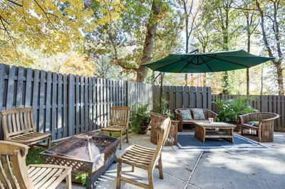 a patio with chairs and a table and an umbrella at Spacious King of Prussia Home with 2 Game Rooms in King of Prussia
