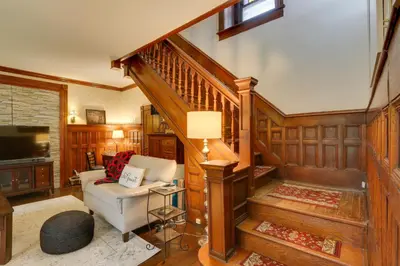 a living room with a white couch and a staircase at Historic Home on Farm, 15 Mi to Williamsport! in Antes Fort