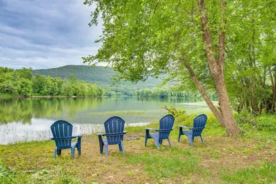 three chairs and a table in front of a lake at Historic Home on Farm, 15 Mi to Williamsport! in Antes Fort