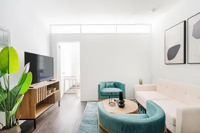 a living room with a white couch and a blue chair at 444-2C Newly renovated 1BR in Hell's Kitchen in New York