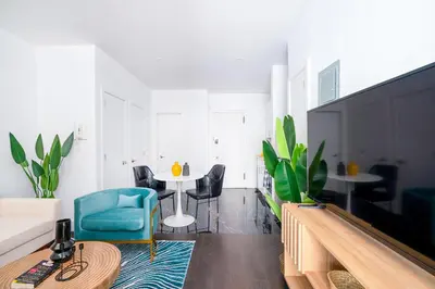 a living room with a table and a blue chair at 444-2C Newly renovated 1BR in Hell's Kitchen in New York