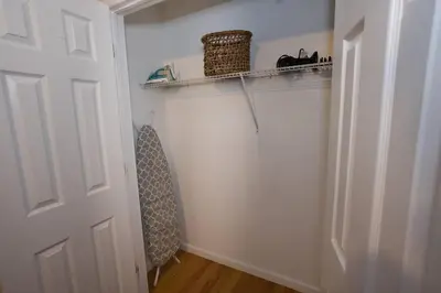 a hallway with a white door and a shelf with a catitcher at Family 3-bedroom home (2nd floor near EWR/Outlet) in Elizabeth