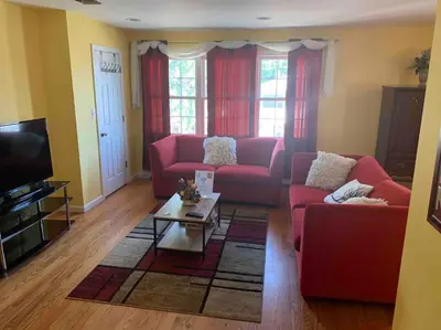 a living room with two red couches and a coffee table at Family 3-bedroom home (2nd floor near EWR/Outlet) in Elizabeth