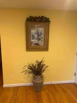 a vase with a plant on a yellow wall with a picture at Family 3-bedroom home (2nd floor near EWR/Outlet) in Elizabeth