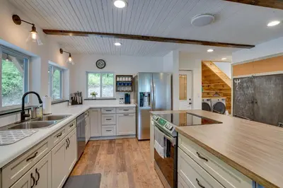 a large kitchen with white cabinets and a wooden ceiling at Secluded Marathon Hideaway with Fire Pit and Views! in Marathon
