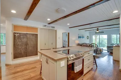 a kitchen with a stove top oven next to a living room at Secluded Marathon Hideaway with Fire Pit and Views! in Marathon