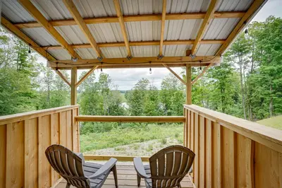a screened porch with two chairs and a table at Secluded Marathon Hideaway with Fire Pit and Views! in Marathon