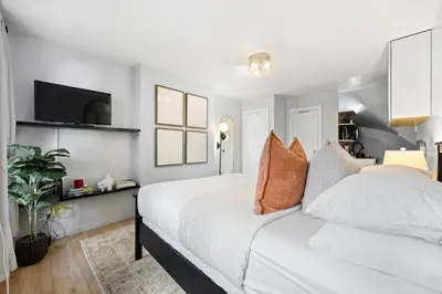 a bedroom with a white bed and a flat screen tv at Studio Haven in Times Square & Nearby Restaurants in New York