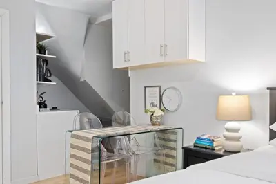 a bedroom with white cabinets and a glass table at Studio Haven in Times Square & Nearby Restaurants in New York