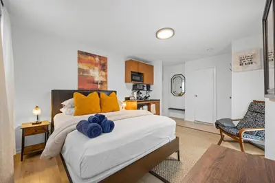 a bedroom with a large bed with yellow pillows on it at Times Square Studio near Restaurants & Shopping in New York