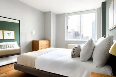 a bedroom with a bed with white pillows and a window at Hells Kitchen 1BR w Pool Gym DM nr Subway NYC-482 in New York