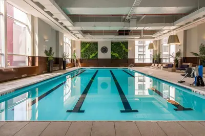 a swimming pool with blue water in a building at Hells Kitchen 1BR w Pool Gym DM nr Subway NYC-482 in New York