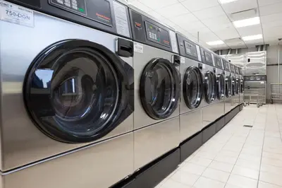 a row of washing machines in a laundrette at Hells Kitchen 1BR w Pool Gym DM nr Subway NYC-482 in New York