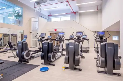 a gym with treadmills and elliptical machines at Hells Kitchen 1BR w Pool Gym DM nr Subway NYC-482 in New York