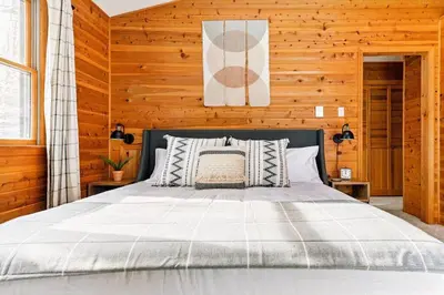 a bedroom with a bed in a wooden wall at Luxe Lake Harmony Home, Game Room, Firepit, Deck in Spilt Rock