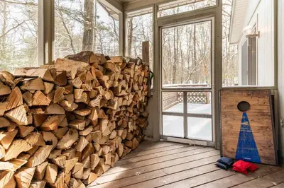 a pile of fire wood in a room with a door at Luxe Lake Harmony Home, Game Room, Firepit, Deck in Spilt Rock