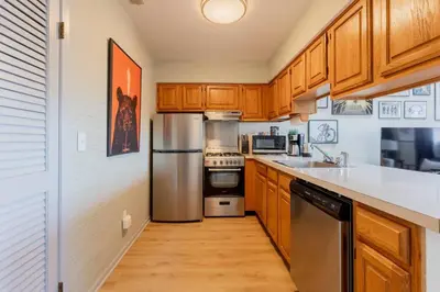 a kitchen with wooden cabinets and a stainless steel refrigerator at Cozy 2BR condo w/ valley views in Vernon Township