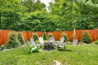 a backyard with a fire pit and chairs and a fence at Hot Tub, Game Room and Fire Pit Pocono Summit Home! in Pocono Summit
