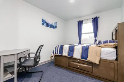 a bedroom with a bed and a desk and a window at Grand Monarch! Best for Extended Stays! in Johnson City