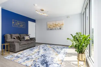 a living room with a couch and a blue wall at Grand Monarch! Best for Extended Stays! in Johnson City