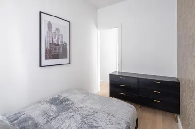 a bedroom with a bed and a dresser at Beautiful 2BD with a Gym near Times Square in New York