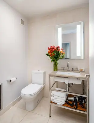 a bathroom with a toilet and a sink and a mirror at Beautiful 2BD with a Gym near Times Square in New York