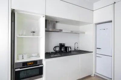 a white kitchen with a stove and a refrigerator at Stylish 1BD near Bryant Park with Washer and Dryer in New York