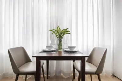 a dining room table with two chairs and a vase on it at Stylish 1BD near Bryant Park with Washer and Dryer in New York