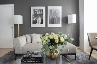 a living room with a couch and a vase of flowers at Stylish 1BD near Bryant Park with Washer and Dryer in New York