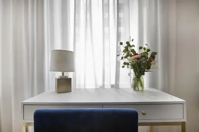 a table with a vase of flowers and a lamp at Stylish 1BD near Bryant Park with Washer and Dryer in New York