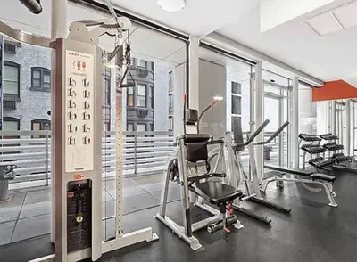 a gym with several treadmills and elliptical machines at Stylish 2BD with Washer and Dryer near Times Square in New York