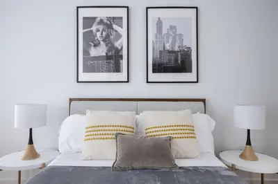 a bedroom with a bed with three pictures on the wall at Beautiful 2BD Apartment near Times Square in New York