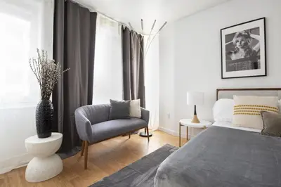 a bedroom with a bed and a chair and a window at Beautiful 2BD Apartment near Times Square in New York