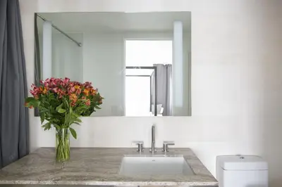 a bathroom with a sink and a vase of flowers at Modern 2BD in Midtown with Washer and Dryer in-unit in New York